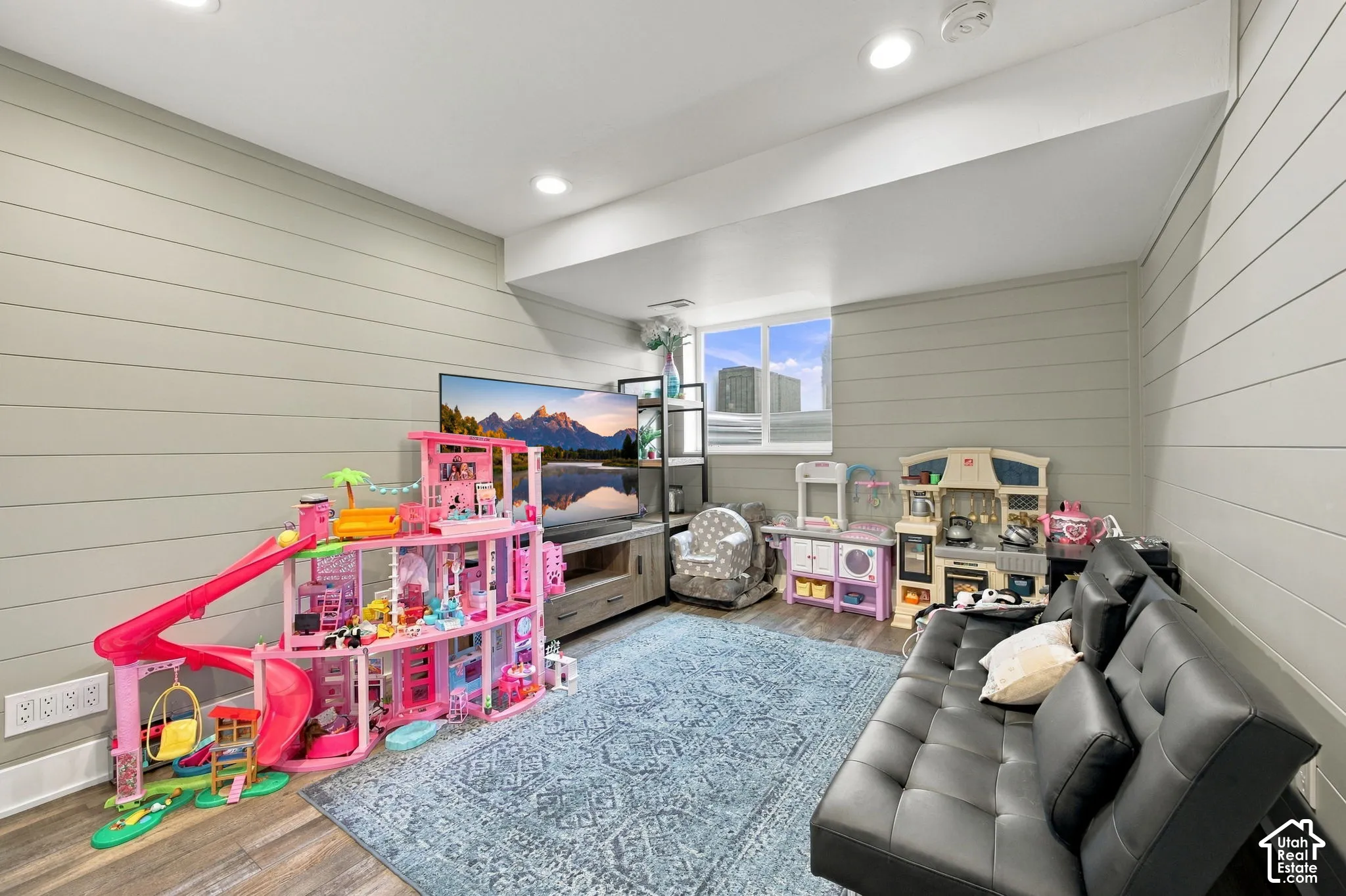Horizontal shiplap wall paneling, recessed lighting, and wood-finish flooring