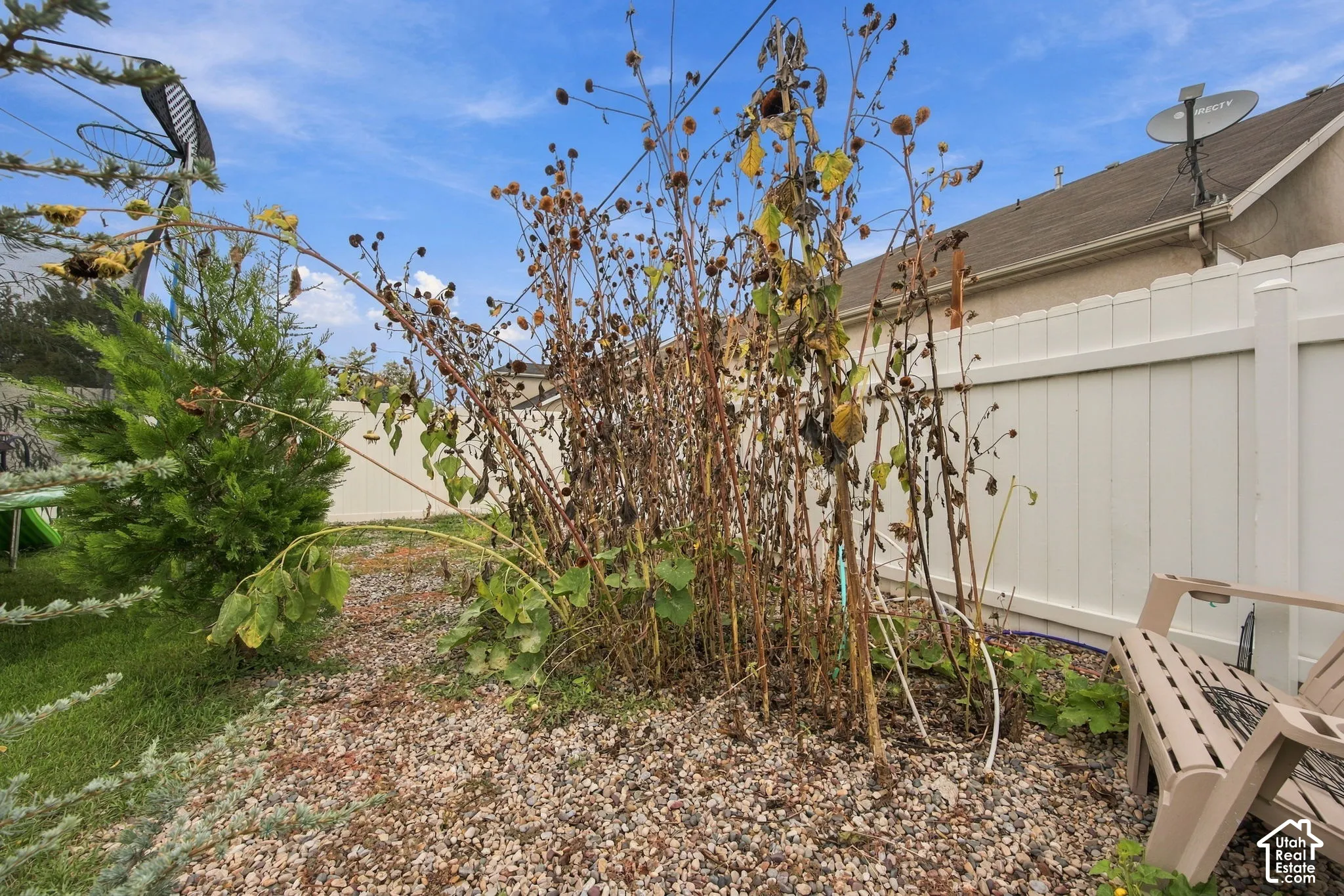 White vinyl privacy fencing and gravel ground cover