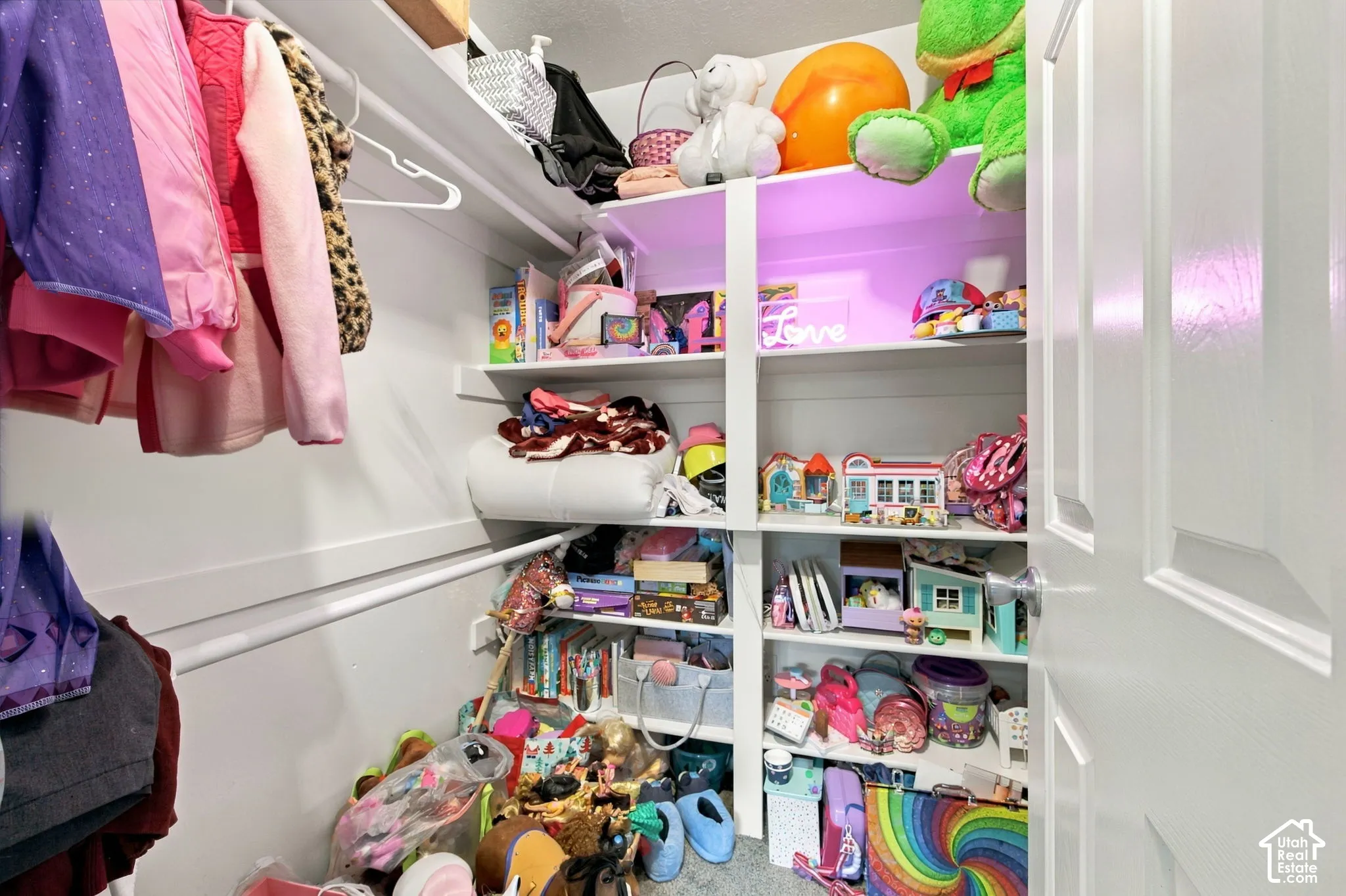 Reach-in closet featuring white-painted wood shelving, white hanging rods, and a six-panel interior door