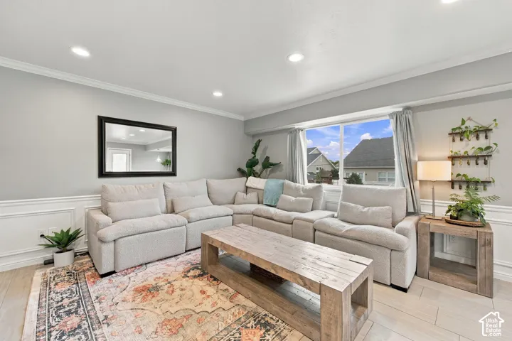 Living area featuring recessed lighting, wood-finish tile flooring, crown molding, and wainscoting