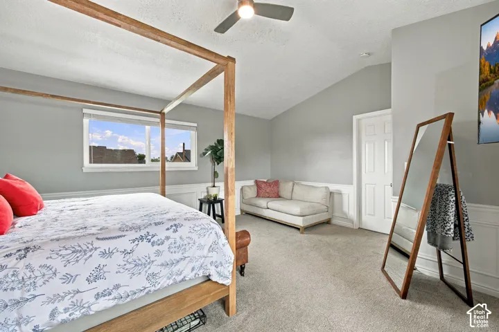 Vaulted ceilings, wainscoting, wall-to-wall carpeting, and a ceiling fan