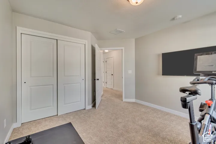 Carpeted flooring, neutral wall tones, white trim, and a built-in wall-mounted television
