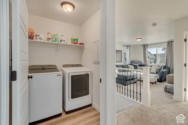 Dedicated laundry area featuring a built-in shelving unit and wood-finish flooring