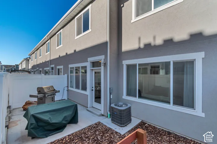 Private patio with concrete surfacing, white vinyl fencing, and a glass-paneled exterior door