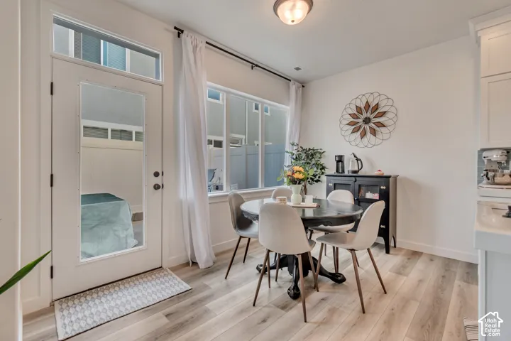 Light wood-finish flooring, white walls, transom window, and a full-light door