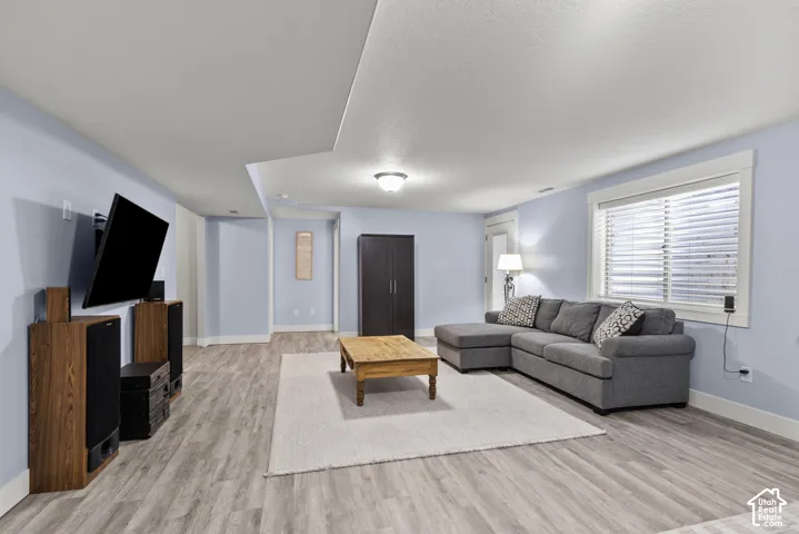 Spacious interior featuring wood-finish flooring, recessed ceiling lighting, and a window with horizontal blinds