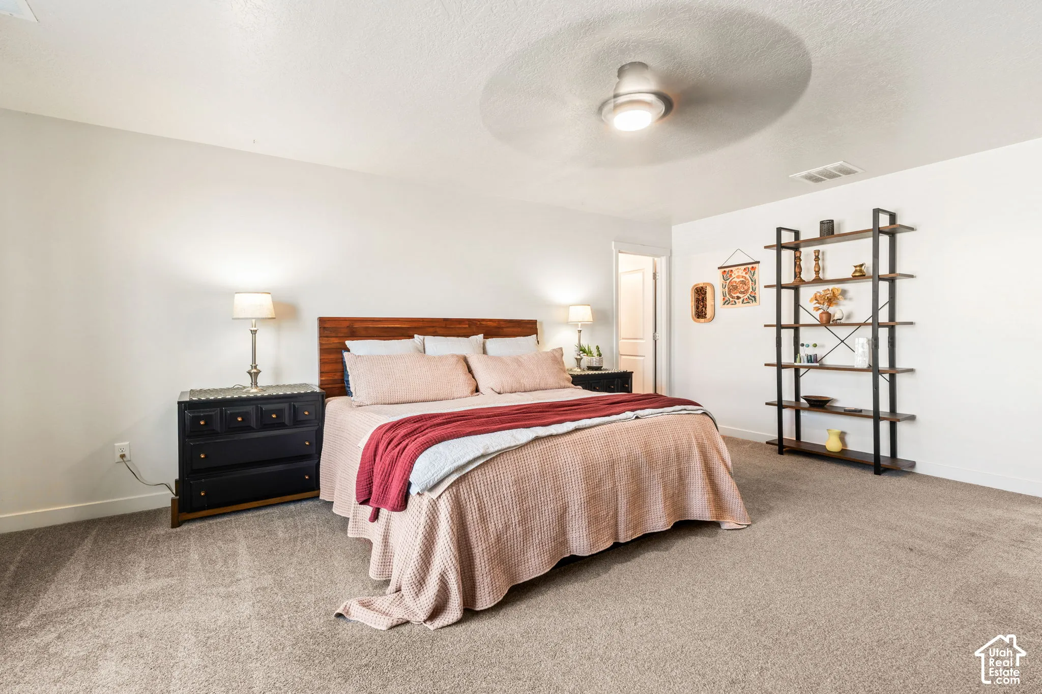 Neutral-toned carpeting, integrated ceiling fan with light fixture, and white interior wall finish