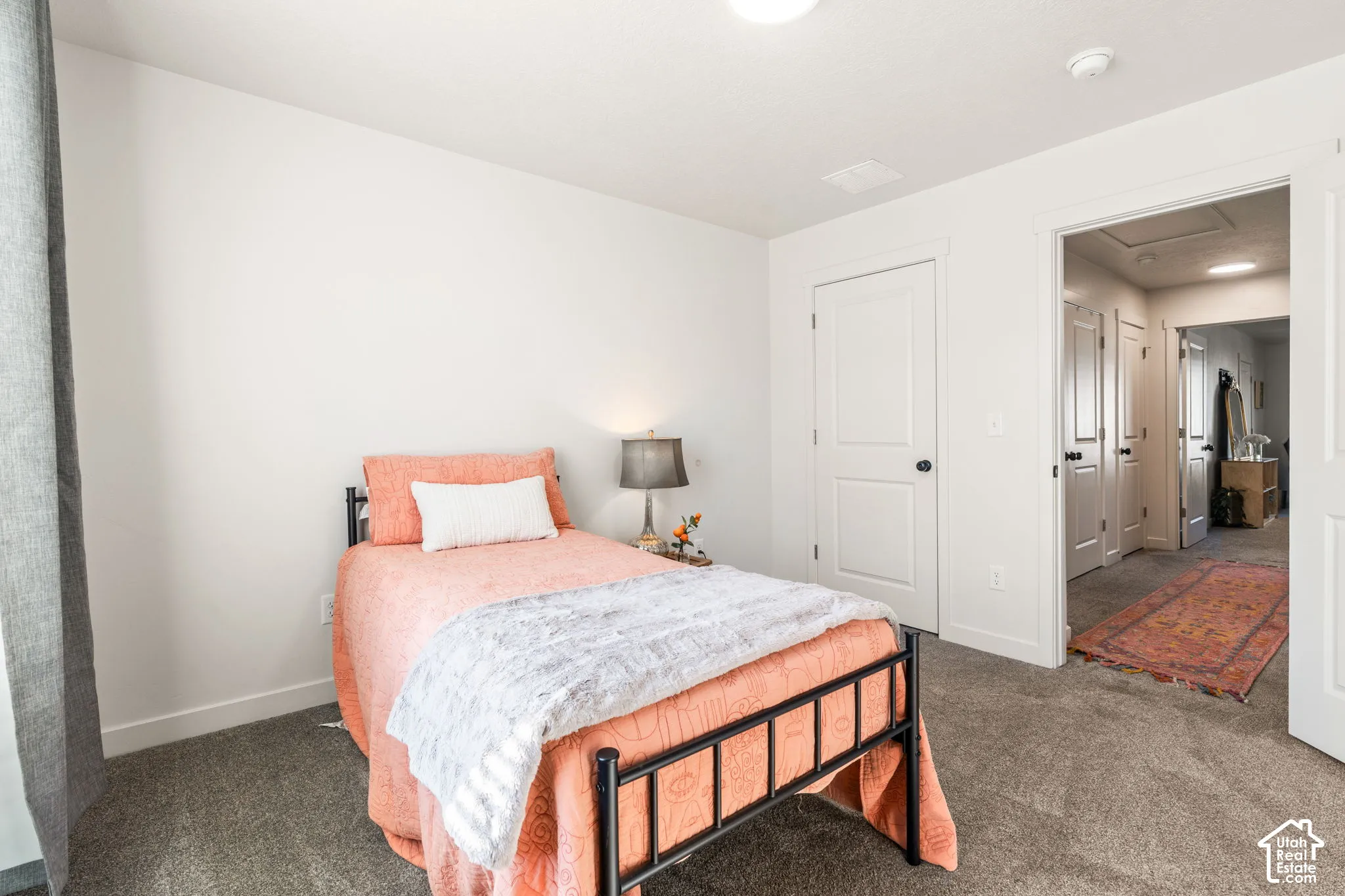 Neutral-toned interior featuring wall-to-wall carpeting, crisp white walls, and multi-panel interior doors with matte black hardware