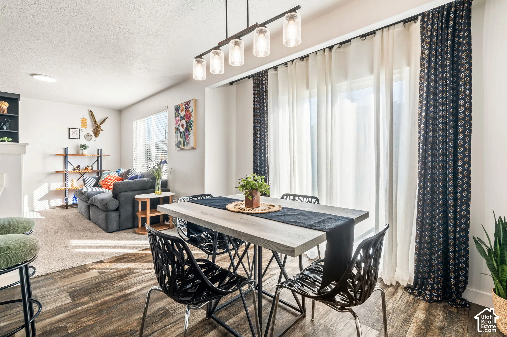 Wood-finish flooring, linear glass pendant lighting fixture, and floor-to-ceiling sliding glass doors