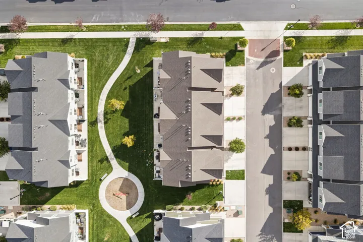 Aerial perspective featuring multi-story residential structures, paved concrete driveways, manicured common lawn areas, and concrete pedestrian walkways