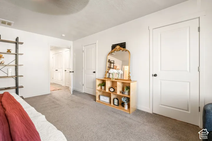 Interior space featuring wall-to-wall carpeting, neutral paint, and white paneled interior doors with matte black hardware