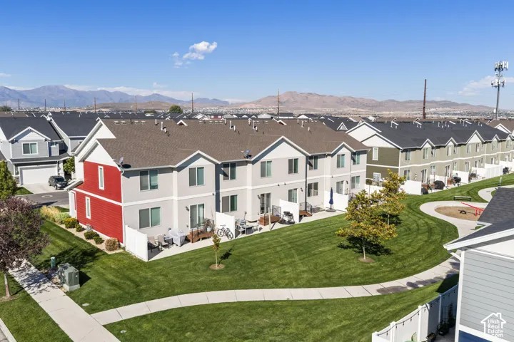 Multi-unit residential structure featuring composite shingle roofing, vinyl siding, concrete patios, and mountain scenery