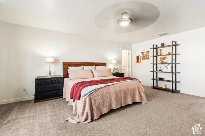 Neutral-toned carpeting, integrated ceiling fan with light fixture, and white interior wall finish