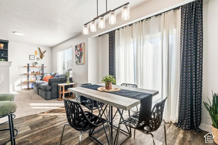 Wood-finish flooring, linear glass pendant lighting fixture, and floor-to-ceiling sliding glass doors