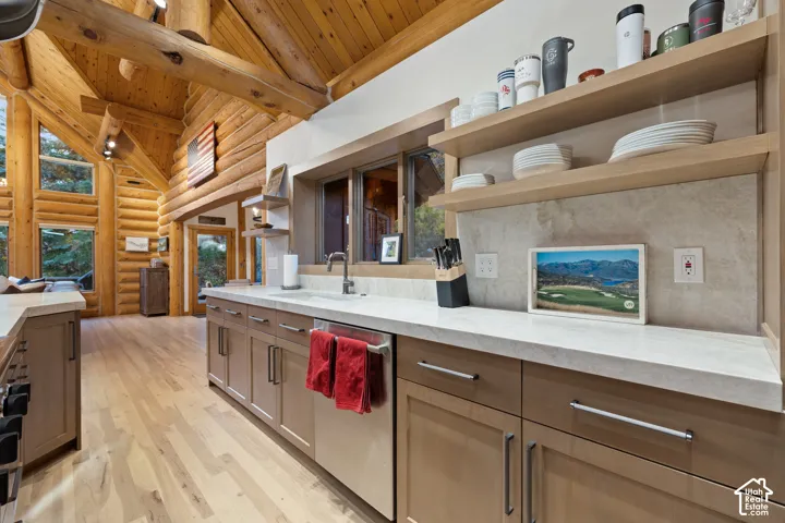 Kitchen featuring open shelves, light wood-style floors, rustic walls, a wood ceiling with exposed beams, and dishwasher