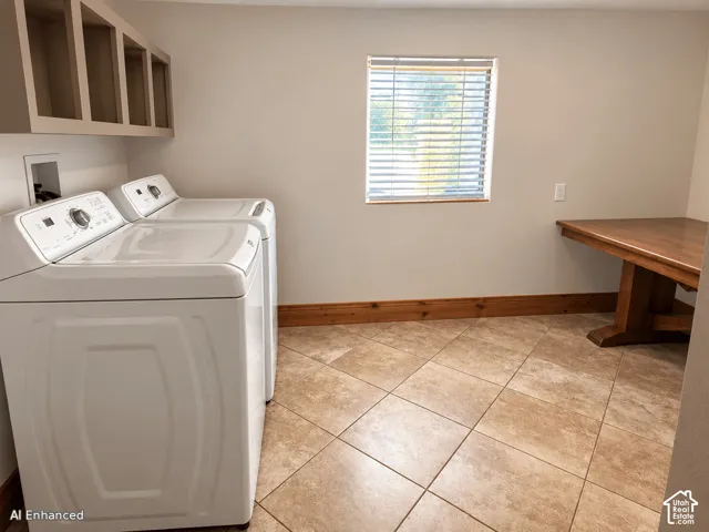 Laundry space featuring tile flooring, built-in wooden cabinetry, a wall-mounted wooden counter, and a window with horizontal blinds