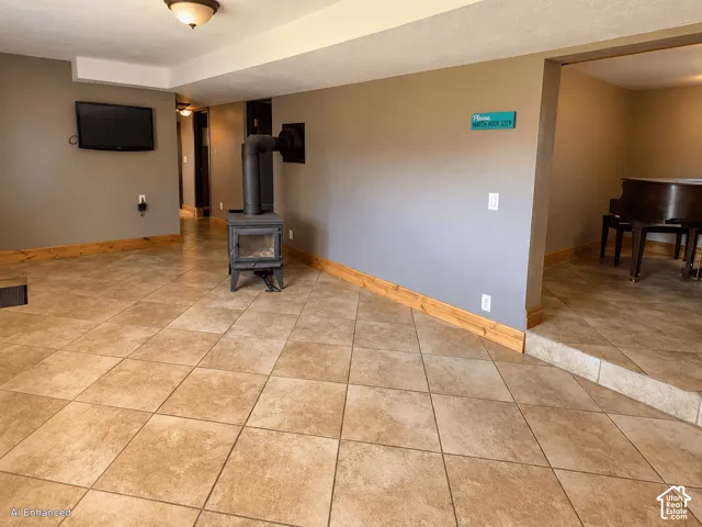 Large-format tile flooring, free-standing cast iron wood stove, and neutral wall tones