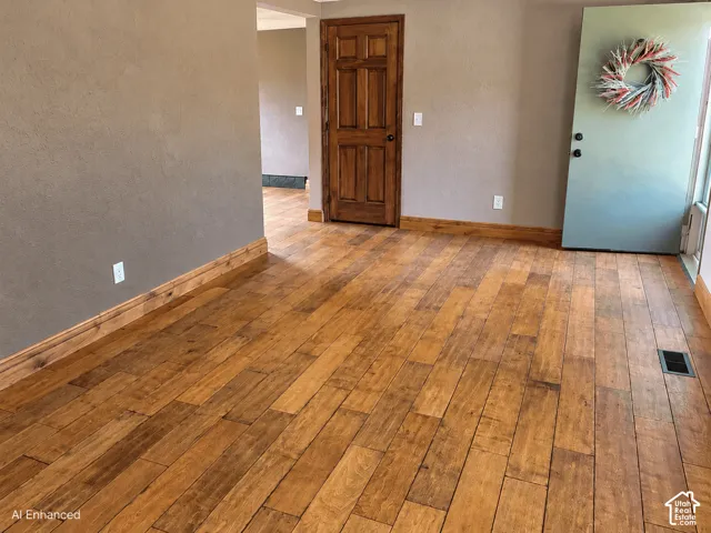 Wood-finish flooring, textured wall finish, and solid wood interior six-panel door