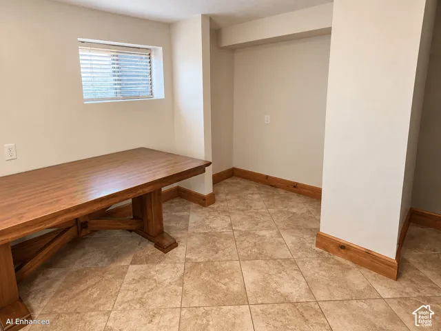 Neutral-toned walls accented by wood-finish trim, ceramic tile flooring, and an inset window with horizontal blinds