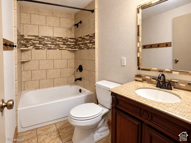 Bathroom featuring a tub-shower combination with decorative tile inlay, stone-finish countertop with an integrated basin, dark wood cabinetry, and a framed mirror with matching tile accents