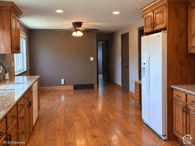Kitchen featuring natural wood cabinetry, stone-surface countertops, wood-finish flooring, and recessed lighting