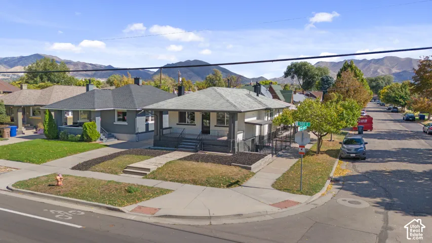 Single-story residence featuring a covered front porch, low-pitched roof, exterior masonry siding, and mountain backdrop