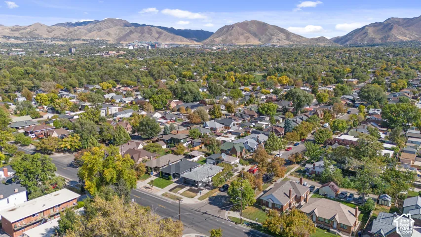 Aerial perspective featuring mature tree-lined streets and mountain range backdrop