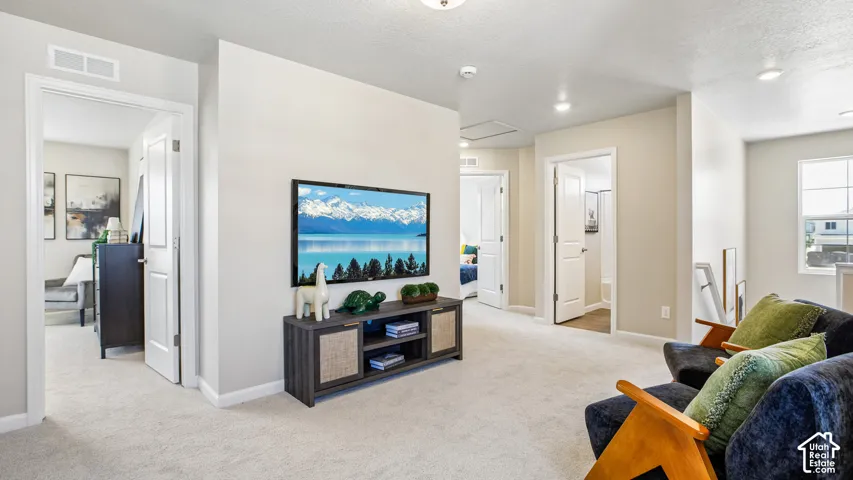 Neutral-toned interior featuring wall-to-wall carpeting, recessed ceiling lighting, and multiple interior doors with white trim