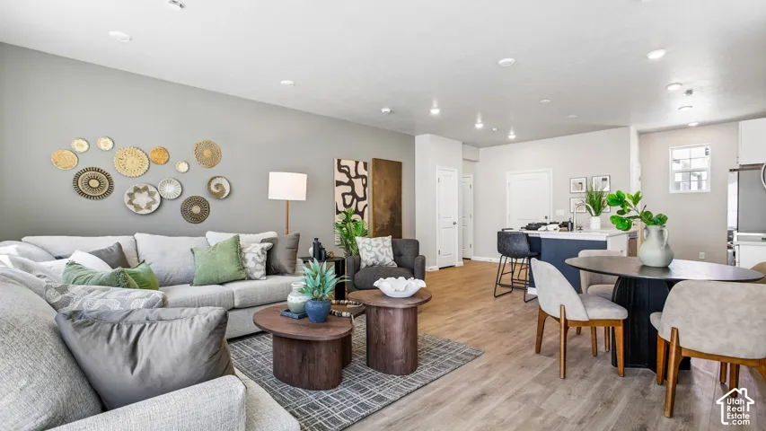 Open-concept interior featuring wood-finish flooring, recessed lighting, and a kitchen island with stone-surface countertop