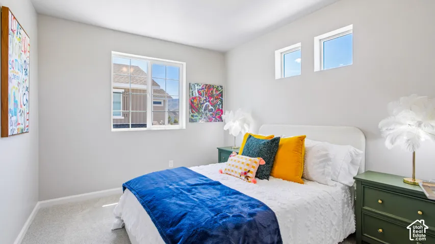 Neutral-toned room featuring plush wall-to-wall carpeting, large grid-pattern windows, and elevated transom windows