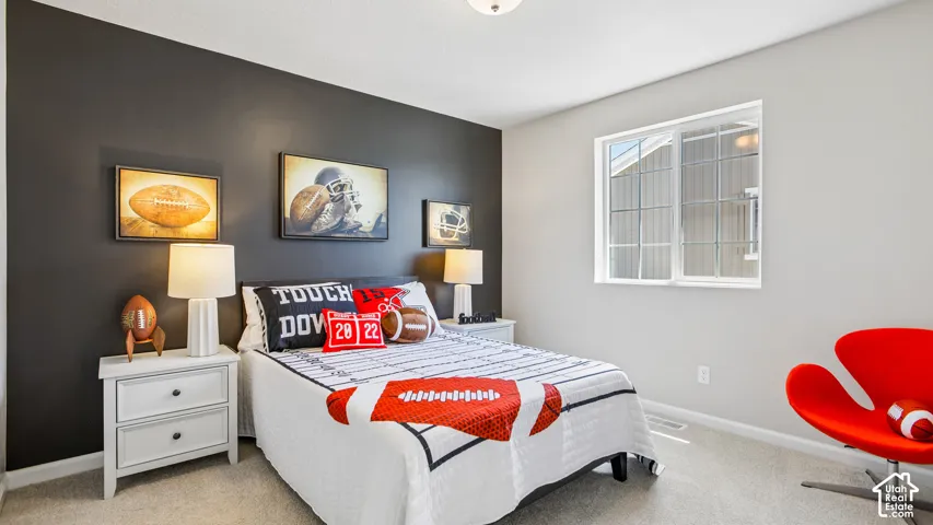 Neutral-toned interior space featuring a dark accent wall, carpeting, and a large sliding window with white trim