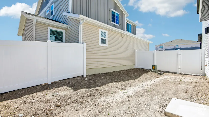 Vinyl siding exterior featuring white privacy fencing and multi-pane windows