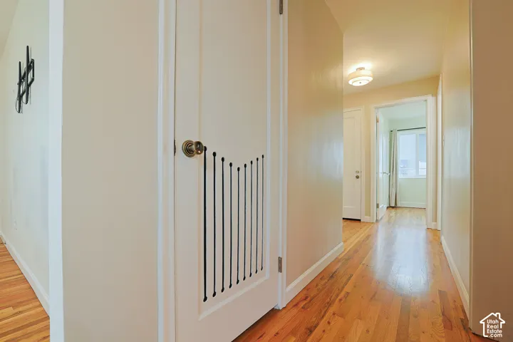Hardwood flooring and interior door featuring a black vertical slat design detail and round metallic hardware