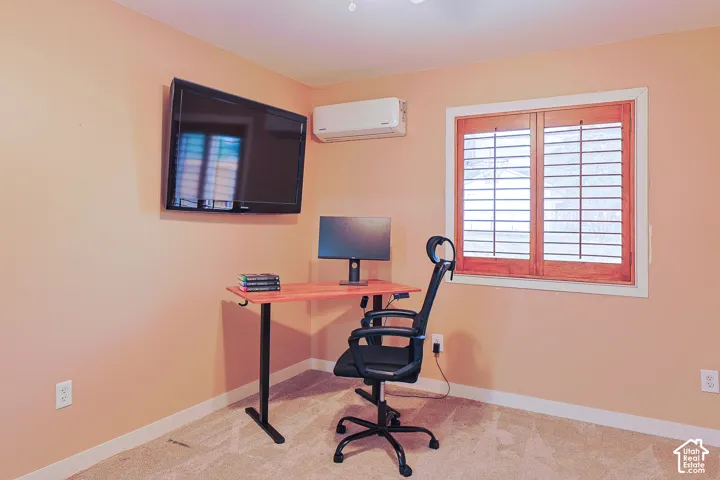 Wall-mounted ductless HVAC unit, window with wood-finish interior shutters, and neutral carpeting