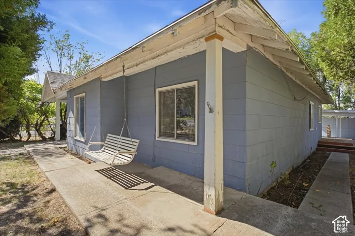 Exterior featuring horizontal siding, a concrete porch, and a built-in porch swing