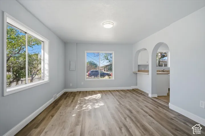 Wood-finish flooring, dual sliding windows, arched architectural detailing, and a pass-through opening