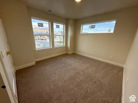 Neutral-toned interior featuring wall-to-wall carpeting, multiple windows, and a horizontal transom window