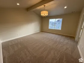 Vaulted ceiling featuring an exposed beam, wall-to-wall carpeting, recessed lighting, and a drum-style pendant fixture