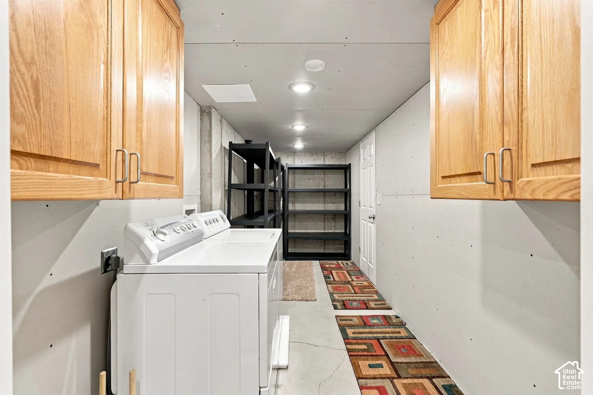 Utility room featuring light-finish wood cabinetry, concrete walls, and recessed ceiling lighting