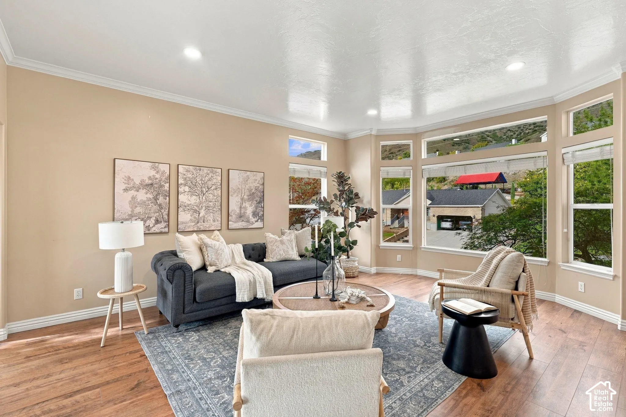 Spacious living area featuring wood-finish flooring, recessed lighting, and a panoramic bay window composition