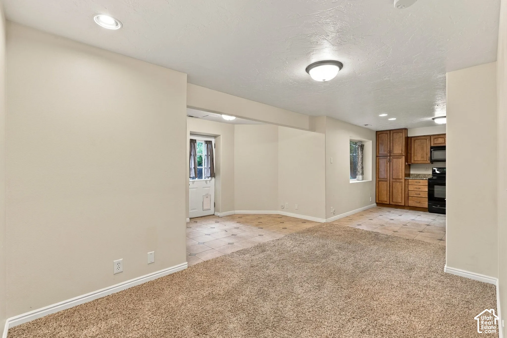 Interior space featuring neutral wall tones, recessed lighting, wall-to-wall carpeting, and tiled flooring