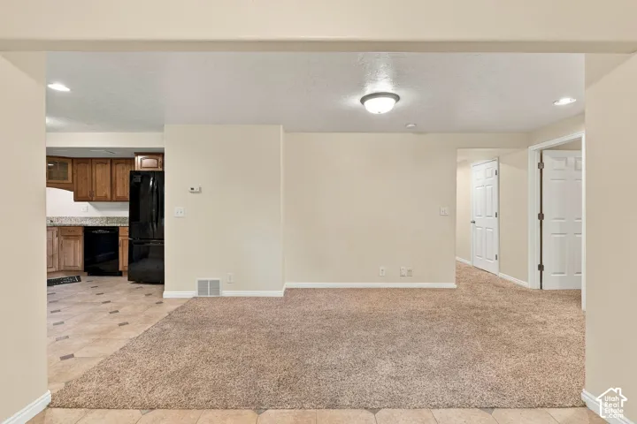 Neutral wall tones, carpeted flooring, tile flooring, wood-finish cabinetry, and interior paneled doors