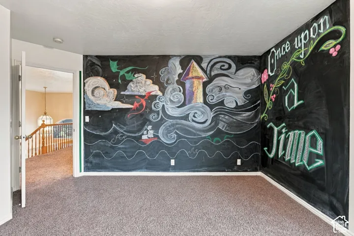 Interior space featuring wall-to-wall carpeting and a floor-to-ceiling chalkboard wall finish