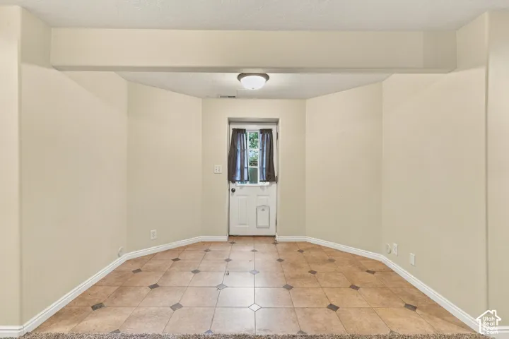 Bay-style alcove featuring ceramic tile flooring with decorative stone-finish accents and a glass-paneled exterior door