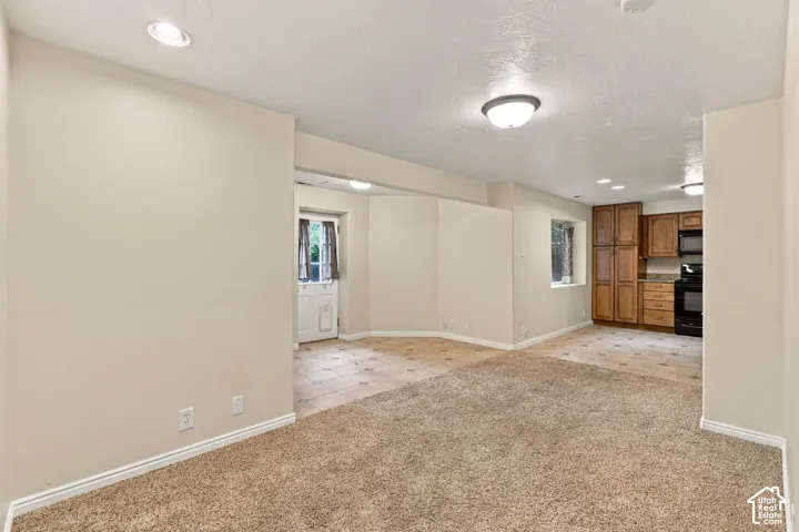 Interior space featuring neutral wall tones, recessed lighting, wall-to-wall carpeting, and tiled flooring