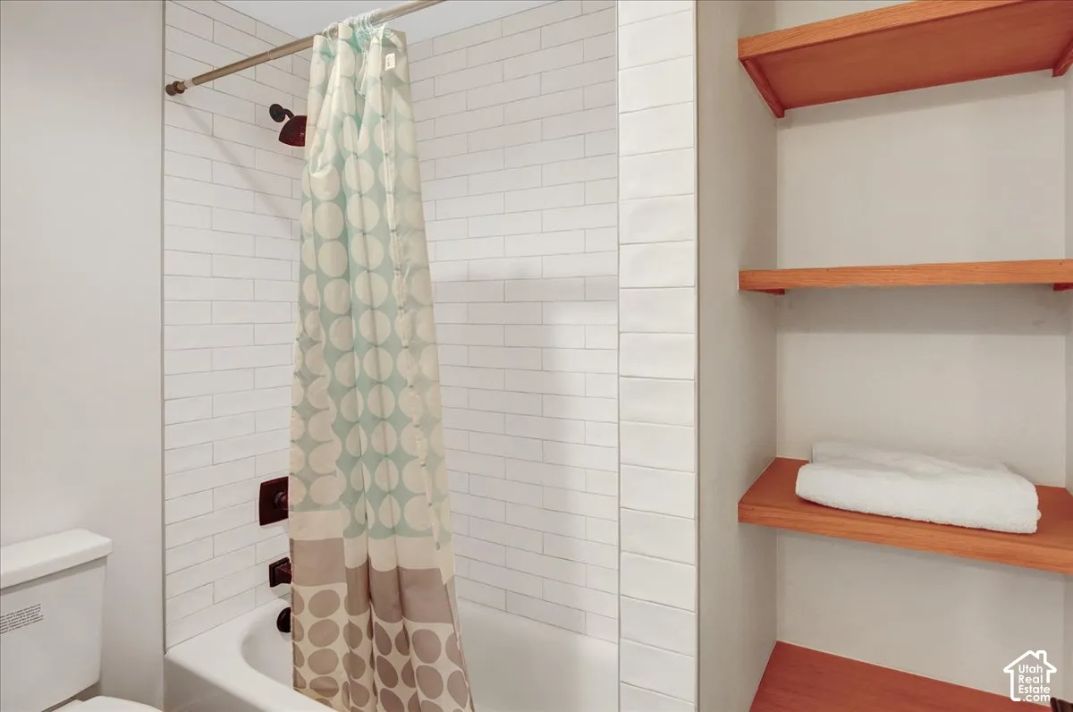 White subway tile shower surround with dark bronze fixtures
