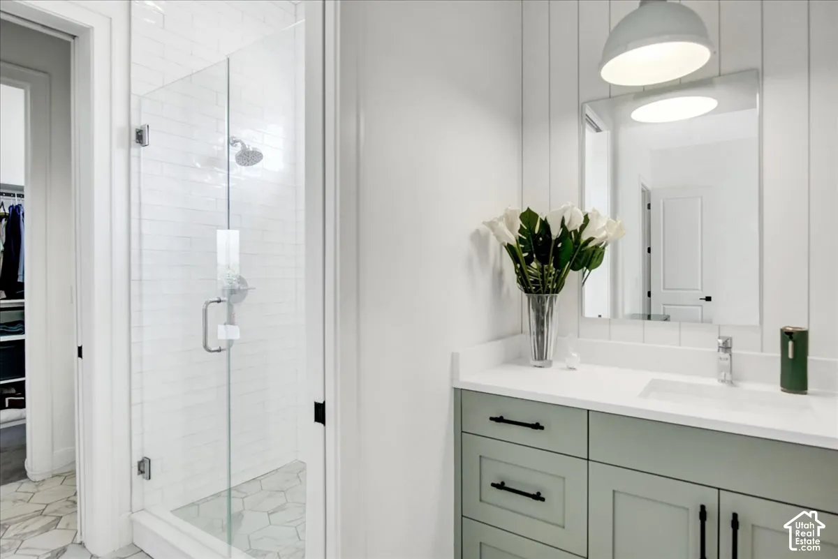 Glass-enclosed shower with subway tile surround, hexagon-patterned flooring, and a rainfall showerhead