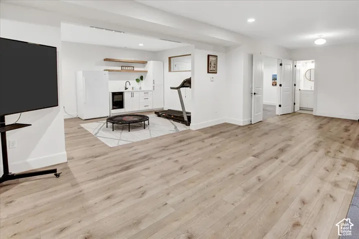 Spacious interior featuring light wood-finish flooring, white walls, and recessed lighting