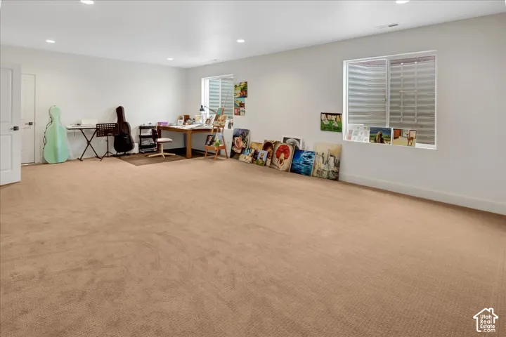 Spacious room with light-colored carpeting and white walls