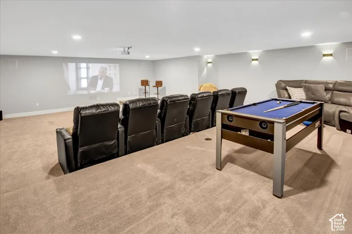 Recessed lighting, wall sconces, projector screen, tiered seating, and carpeted flooring